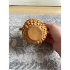 a hand holding a wooden object on top of a carpeted floor next to a door