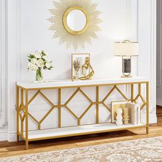 a white and gold console table with flowers on it in front of a large mirror