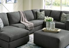 a living room with a gray couch and ottoman