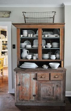 an old china cabinet with dishes on it