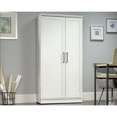 a tall white cabinet sitting next to a dining room table