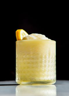 a glass filled with an orange slice and ice