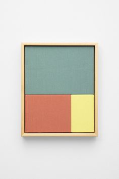 a wooden frame with three different colored squares on the front and back of it, against a white wall