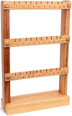 a wooden shelf with four pegs on it