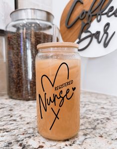 a glass jar filled with liquid sitting on top of a counter next to coffee beans