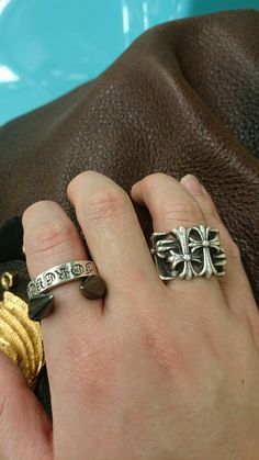 a person wearing two different rings on their fingers, one with a cross in the middle