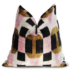 a pink, black and gold pillow on a white background