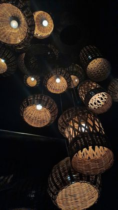 wicker lamps hanging from the ceiling in a dark room