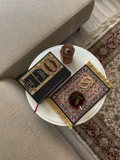 a white table topped with a book on top of a rug next to a cup and saucer