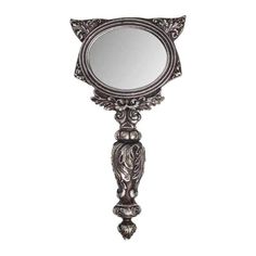 an ornate mirror is hanging on the wall, with a cat's head at the bottom