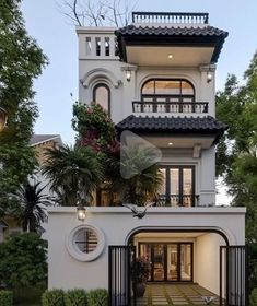 a large white house with lots of windows and balconies on the top floor