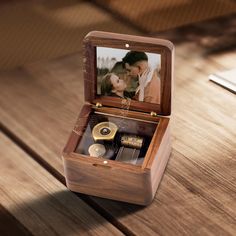 an open wooden box with a couple's photo inside