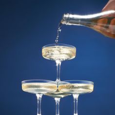 champagne being poured into three wine glasses