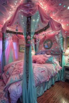 a bed with lights on the ceiling and canopy over it in a room that has wooden floors