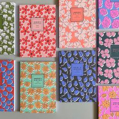 six notebooks lined up in different colors and designs, each with a flower pattern