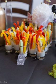 there are many small cups with food in them on the table, including carrots