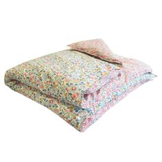 two bedspreads with floral print on them, one is folded and the other has a pillow