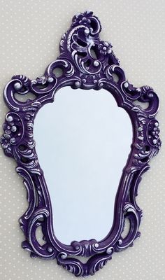 an ornate purple mirror hanging on the wall