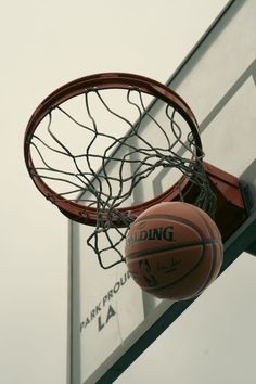 two basketballs that are in the air next to a hoop