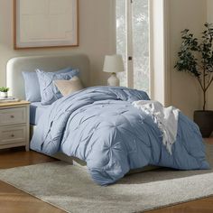 a bed with blue comforter and pillows in a room