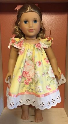 the doll is wearing a yellow dress with pink flowers on it