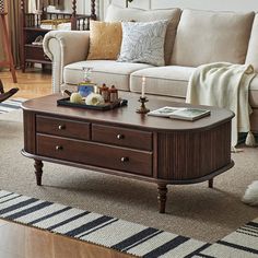 a living room with a couch, coffee table and rugs on the hardwood floor