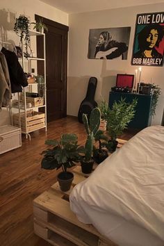 a bed room with a neatly made bed and plants