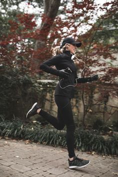 a woman is running in the park with headphones on and ear buds attached to her ears