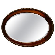 an oval wooden mirror is shown against a white background