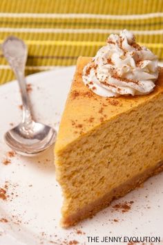 a slice of pumpkin pie on a white plate with a fork and napkin in the background