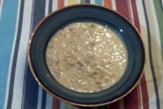 a bowl of oatmeal sitting on top of a striped table cloth