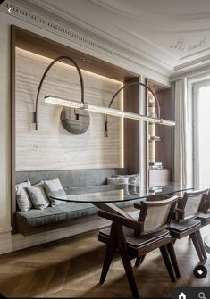 a living room filled with furniture and a glass table surrounded by wooden flooring next to a window