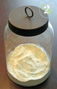 a jar filled with white powder sitting on top of a wooden table next to a black lid