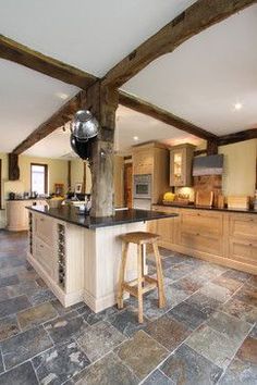 a kitchen with stone flooring and wooden beams