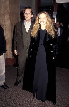 a man and woman standing next to each other in front of a crowd at an event