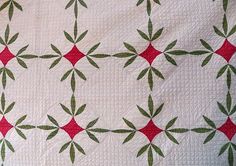 a white quilt with green and red designs on it