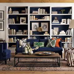 a living room filled with furniture and bookshelves covered in blue bookcases