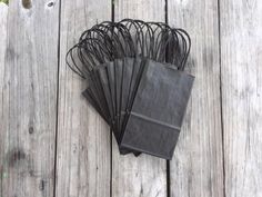 black paper bags on wooden planks with string attached to the top and bottom one