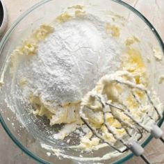 a mixing bowl filled with flour next to a whisk