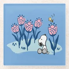 a polar bear sitting in front of some pink tulips on a blue background