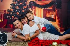 a family laying on the floor in front of a christmas tree