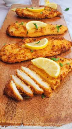 air fryer chicken cutlets on a cutting board with lemons and parsley