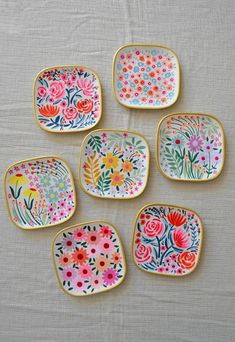 six small plates with flowers painted on them