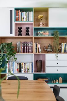 a wooden table sitting in front of a book shelf filled with books