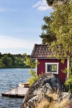 a small red house sitting on top of a lake