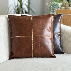 two brown pillows sitting on top of a white couch