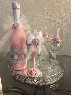 there is a wine bottle and two glasses on the table with it's pink shoes