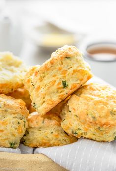 several biscuits stacked on top of each other with dipping sauces in the back ground