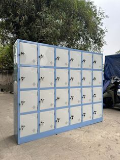 a bunch of lockers that are sitting in the dirt next to a motorcycle and trees