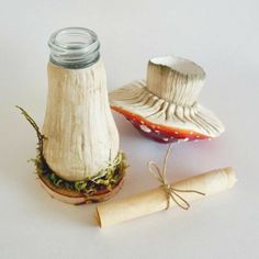 an old fashioned salt shaker next to a miniature hat